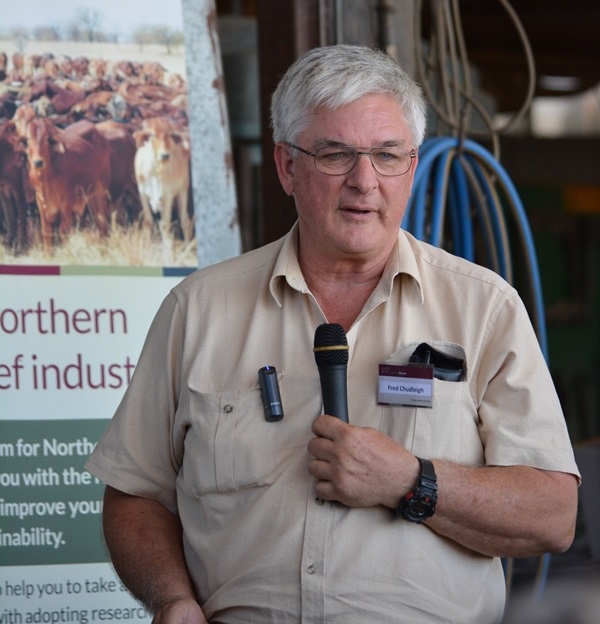 Fred stands with a microphone in front of a FutureBeef banner at a set of cattle yar