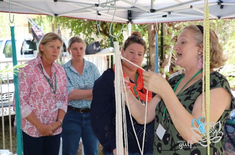 Women watch as the team leader participates in a craft session as part of an event funded by the Drought and Climate Adaptation Program. DCAP