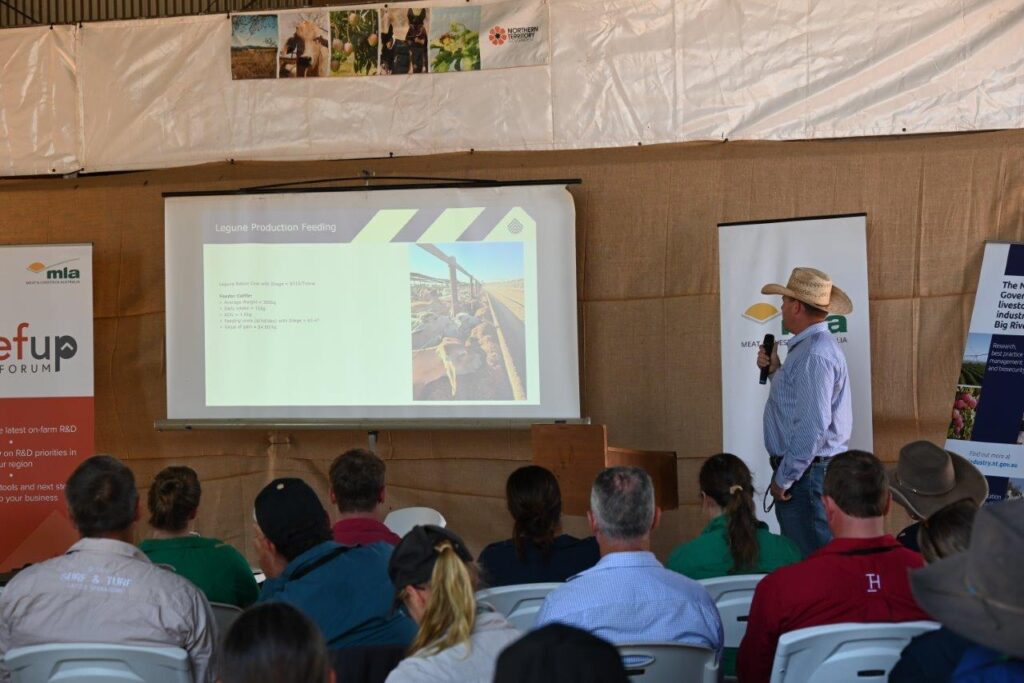 Photo of Ben Wratten giving his presentation to a group of forum participants seated in a shed.