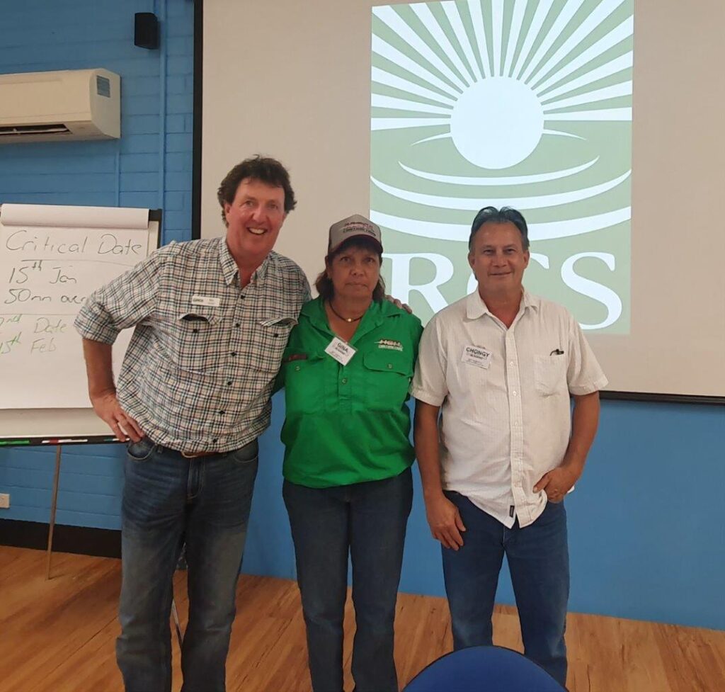 A photo of Nic Kentish, Gina and Chongy Howard standing together in front of the RCS PowerPoint presentation.