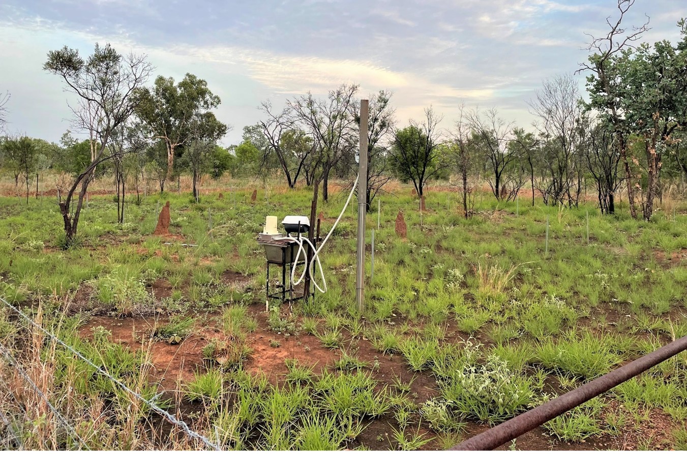 A small table with gadgetry and a pipe next to it in a small paddock.