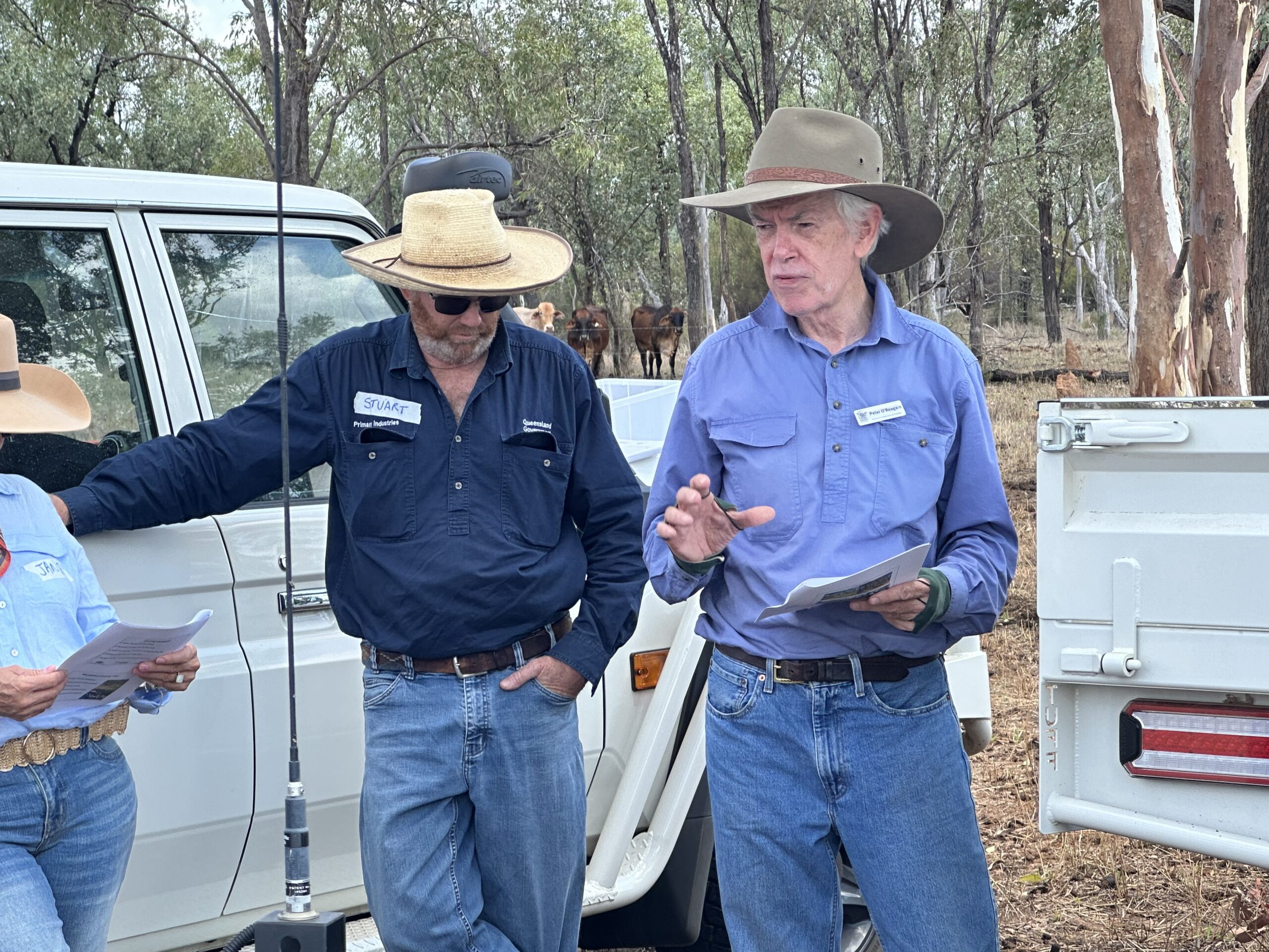 Peter and Stuart standing in front of a Toyota speaking to a group of producers