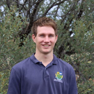Livestock Extension Officer standing in front of trees