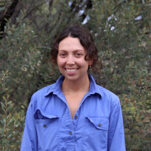 Pastoral Technical Officer standing in front of trees