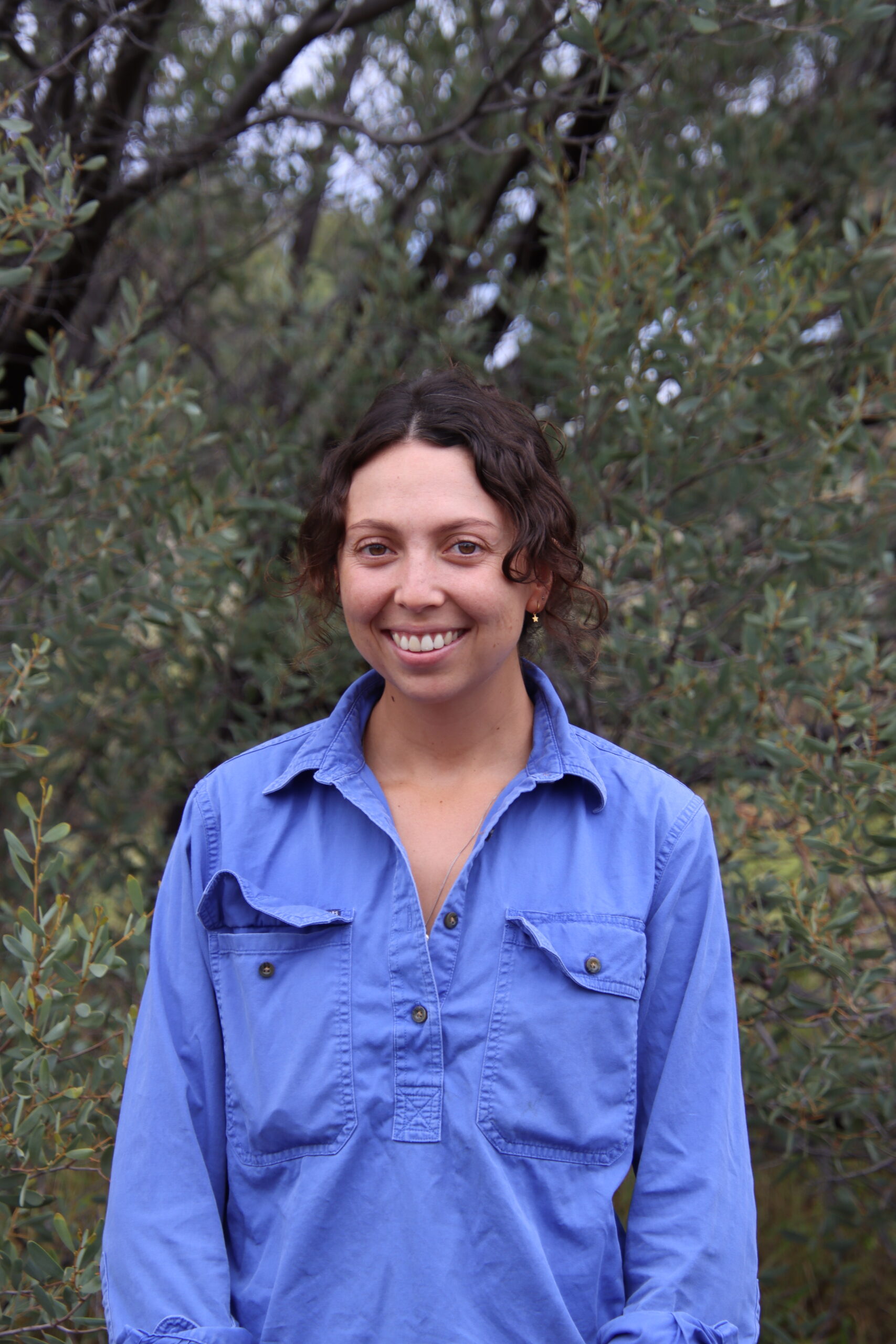 Pastoral Technical Officer standing in front of trees