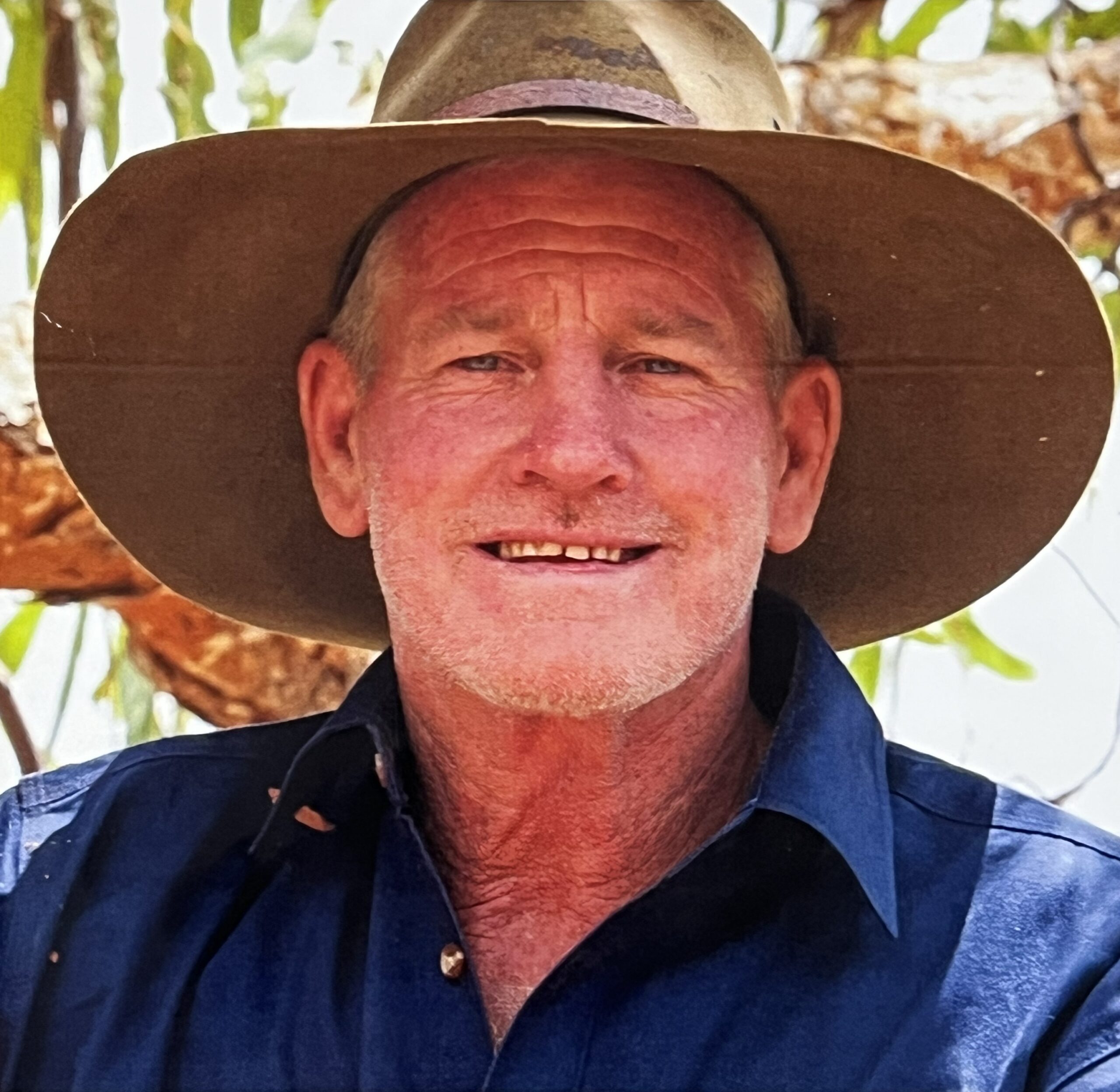 Portrait photo of Tommy Saunders wearing a blue work shirt and a big hat.