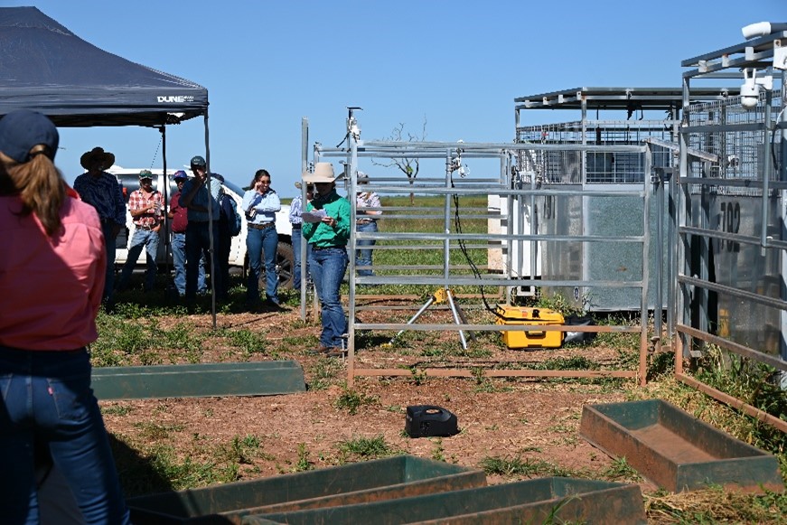 Gemma Somerset (ZNE Ag-CRC) stands in the sun presenting to the DDRF field day attendees as she describes how the greenfeed machines will be used in a producer demonstration site