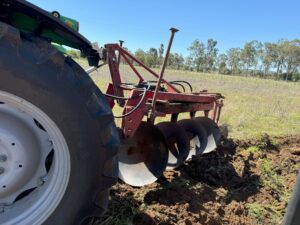 Producer near Goomeri showing fellow members how a reversible plough works up country.