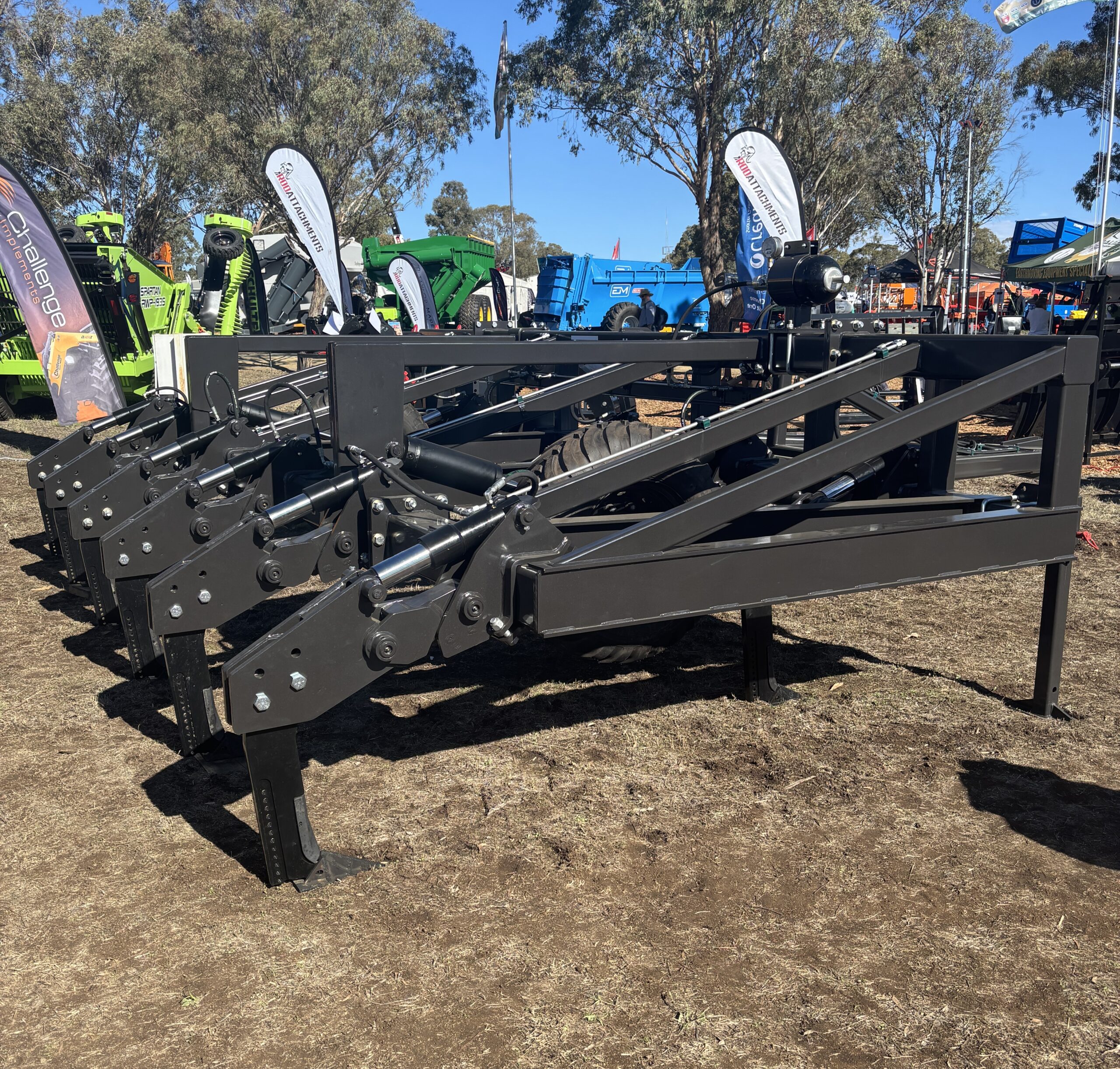 Large steel frame with 6 hydraulic rippers attached.